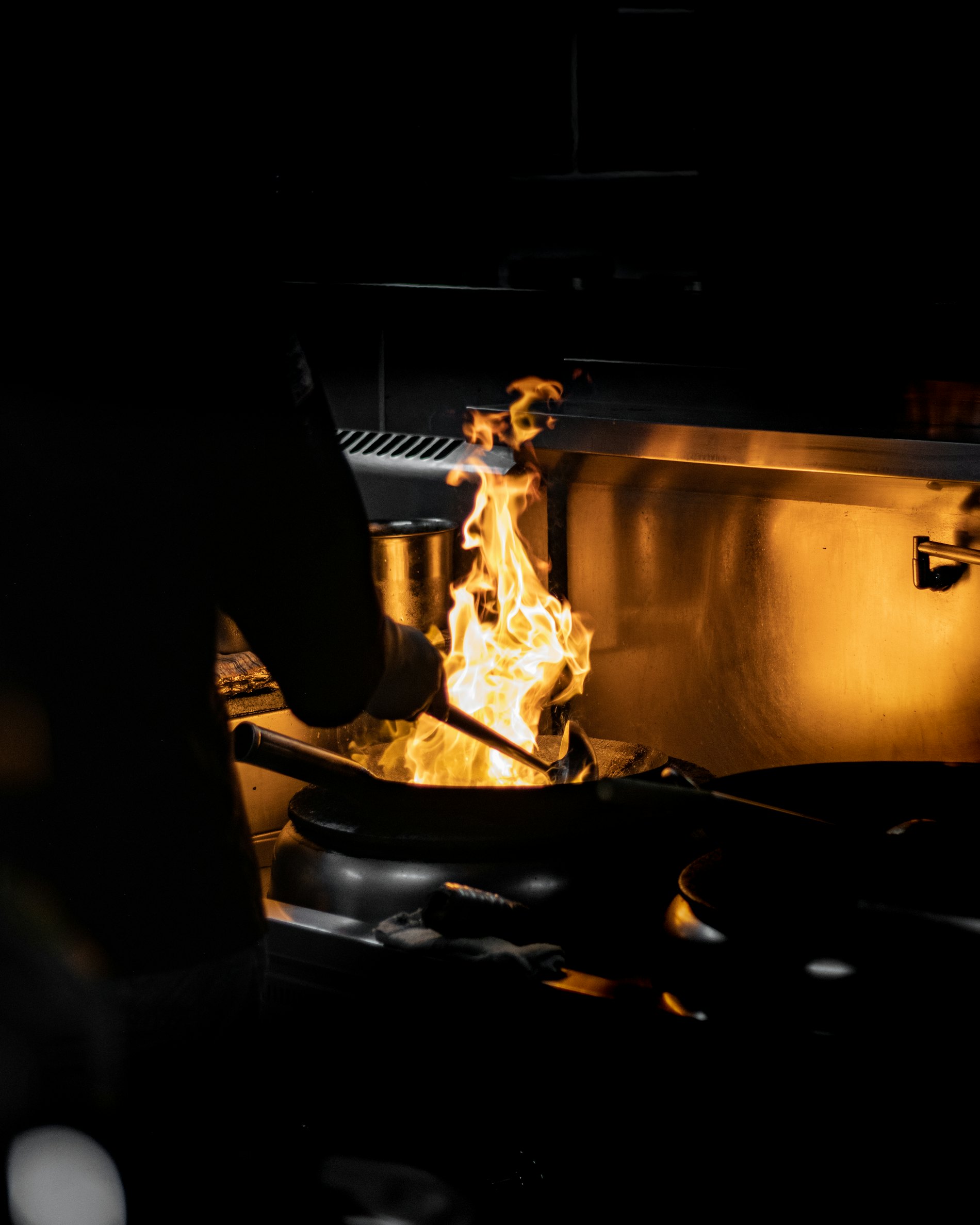 Llama alta sobre el fuego de una cocina a oscuras