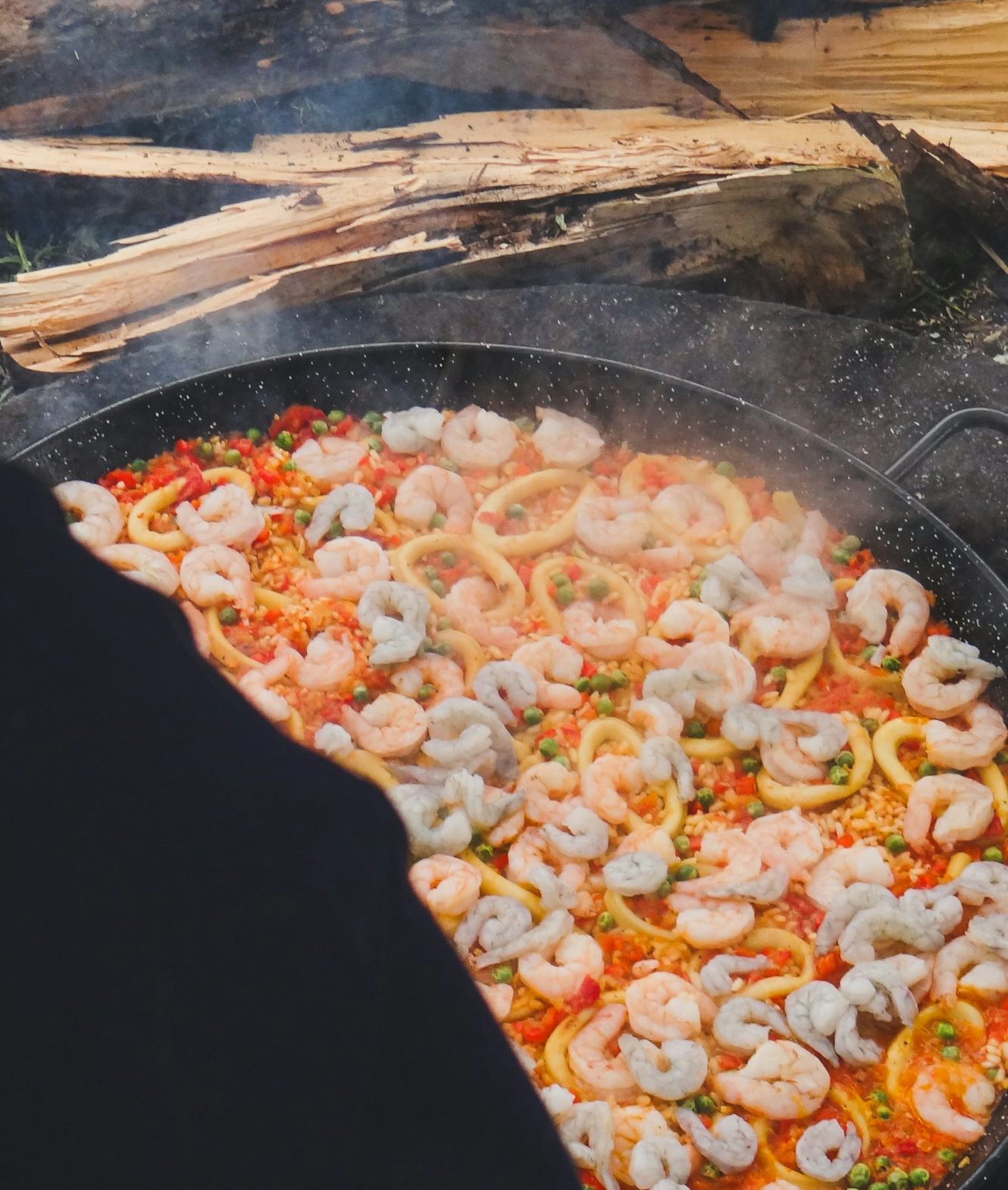 Paella cocinándose sobre leña