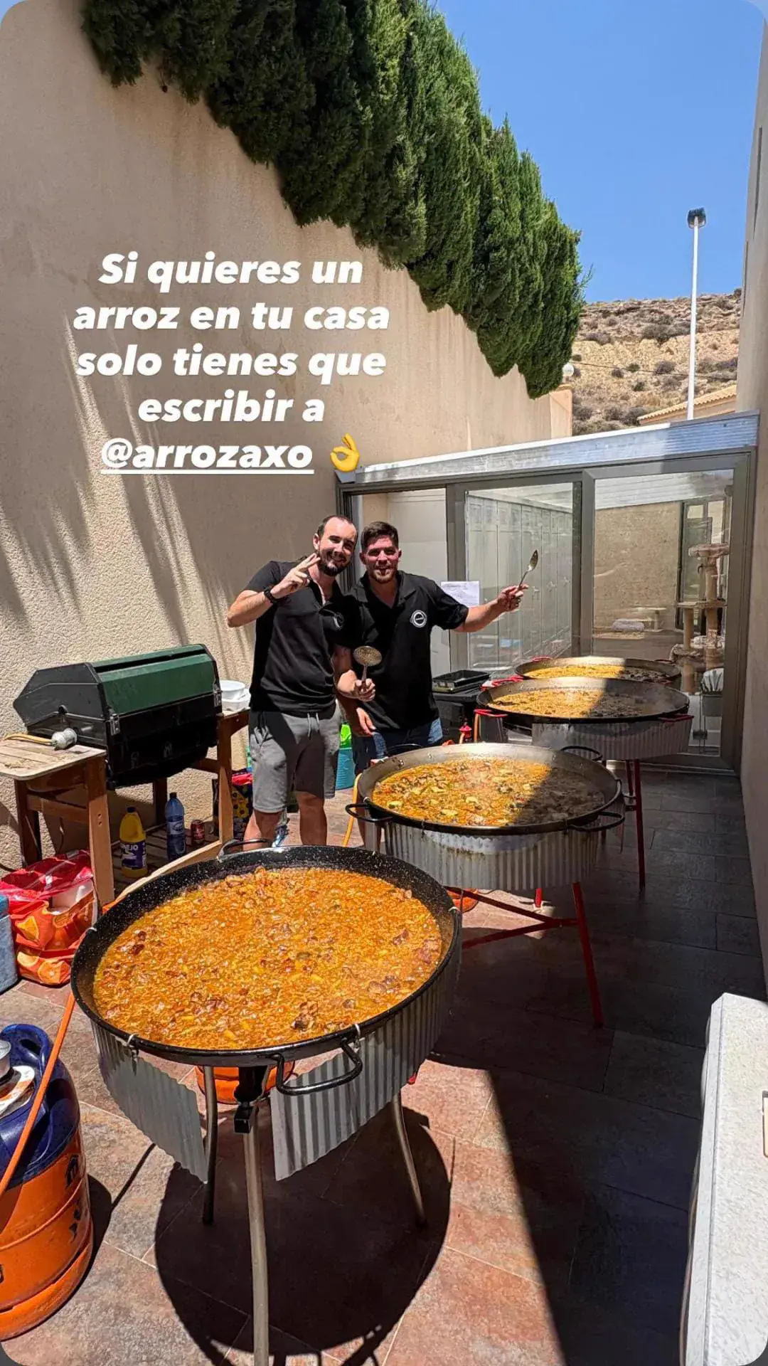 El equipo de ArrózAXO con tres paellas en un evento