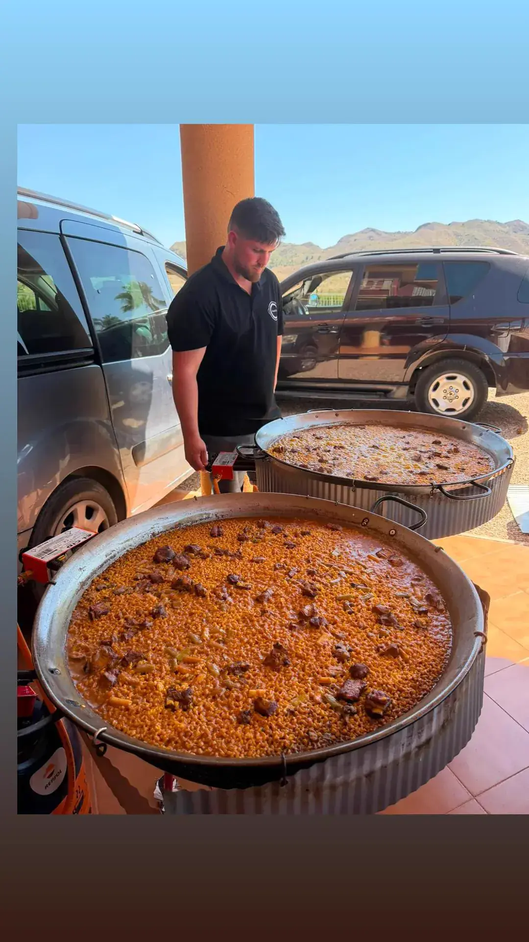 Pedro cocinando dos paellas grandes en un evento